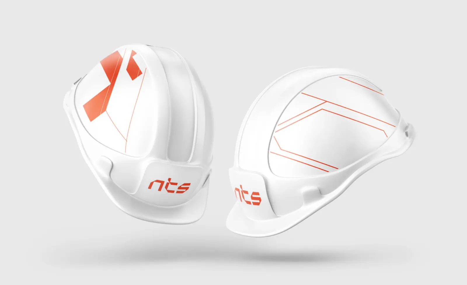 Two white NTS safety helmets with the orange logo and angled line graphics on the sides