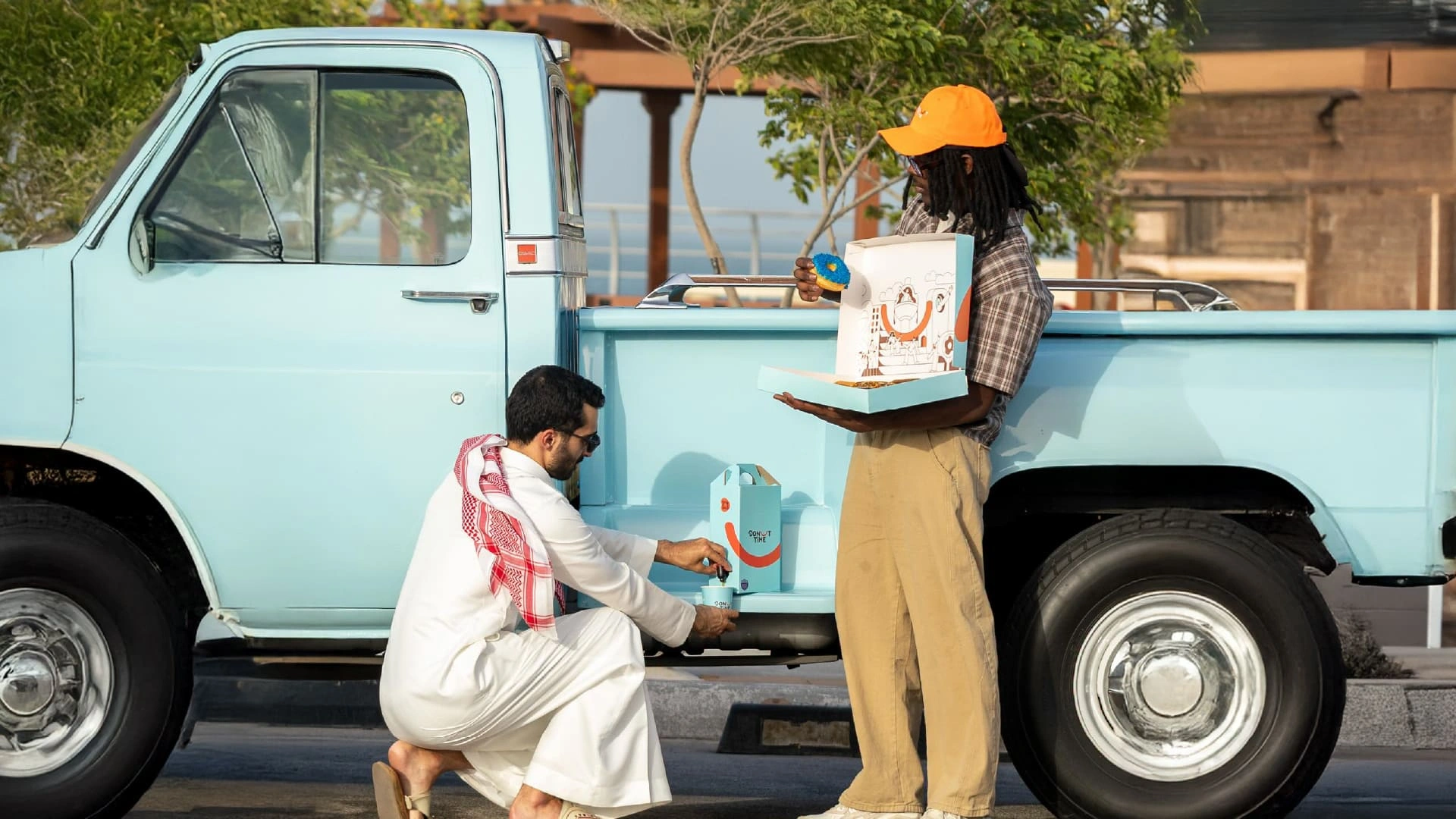 Donut Time line illustration of a Saudi family, a father and child with a mother in hijab, surrounded by donuts, hot air balloons, palm trees, skaters and Riyadh towers in orange, brown and sky blue